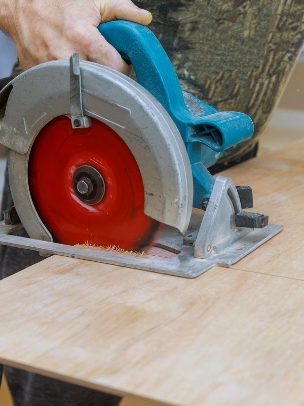 Carpenter cutting plywood with a circular saw