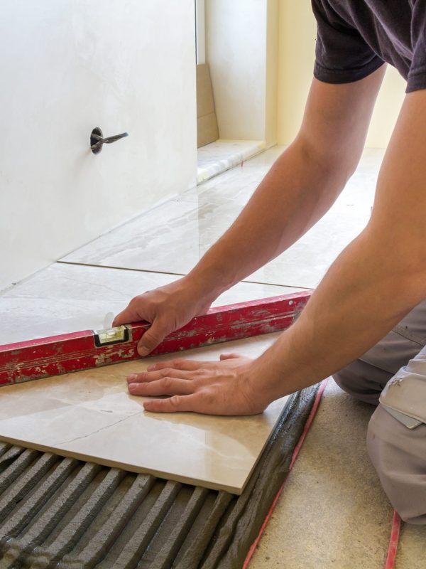 Tiler installing ceramic floor tiles